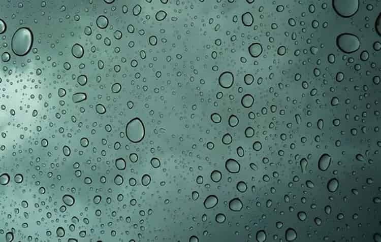 duże krople wilgoci na szybie okiennej jako wynik nadmiernej kondensacji w pomieszczeniu