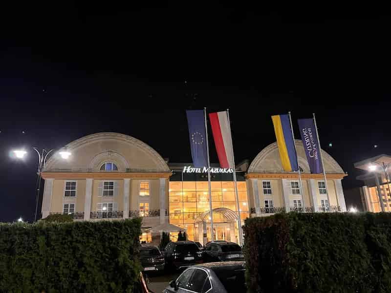 budynek Hotelu Mazurkas w Warszawie nocą z iluminacją i flagami podczas trwania konferencji branżowej