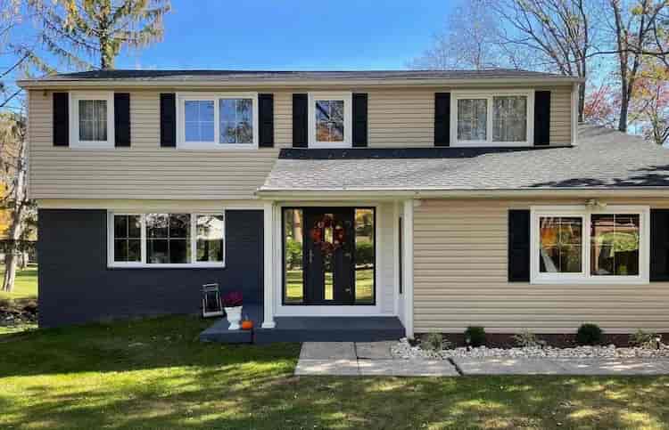 dwupiętrowy dom jednorodzinny z nowo zainstalowanymi oknami PCV i drzwiami wejściowymi