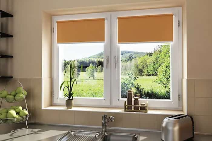 zainstalowane dwuskrzydłowe okno PCV z pomarańczowymi roletami w kuchni
