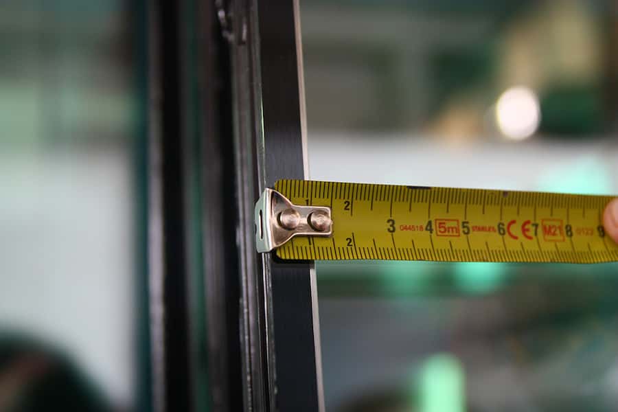 pomiar głębokości uszczelnienia wt&oacute;rnego pakietu szybowego za pomocą miarki w celu sprawdzenia zgodności z normami