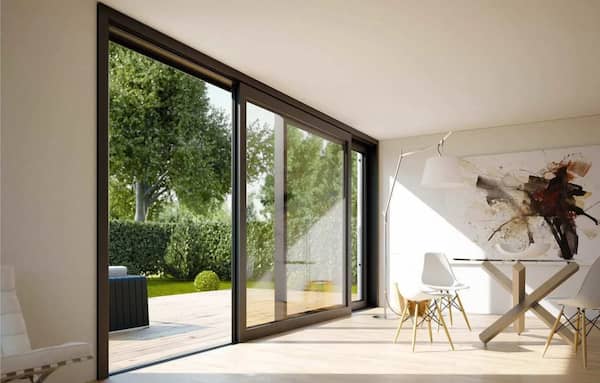 nowoczesny salon z dużym przesuwnym oknem panoramicznym i widokiem na ogr&oacute;d