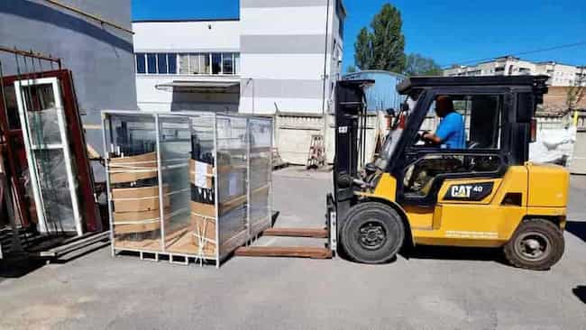 gotowe do wysyłki okna PCV na drewnianej palecie, solidnie zabezpieczone folią opakowaniową i taśmami